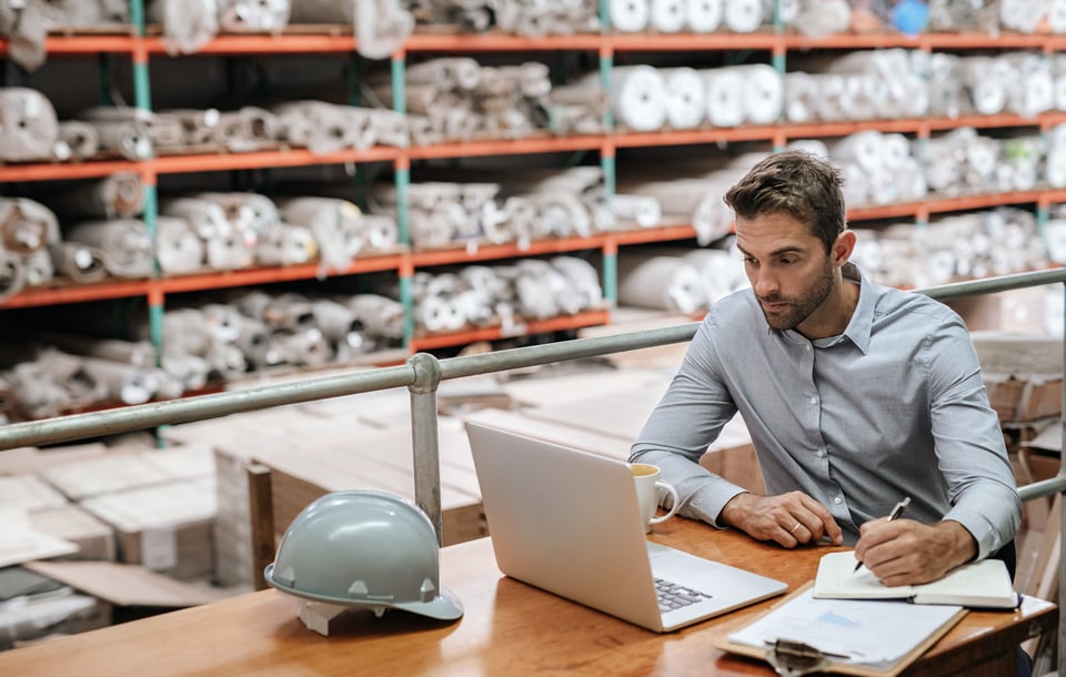 Procurement professional checks for duplicate transactions via his laptop to help reduce MRO costs